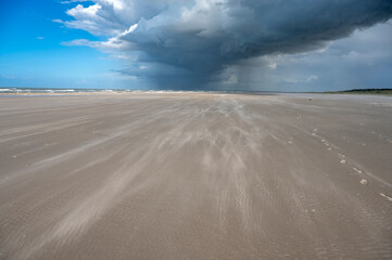 Fototapeta na wymiar Strand auf Juist bei Sturm mit wegtreibenden Sand
