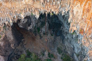 Aerial top view of tourist sprinkle the rope at Spirit Well Cave, Pang Mapha District, Mae Hong Son, Thailand. Adventure activity lifestyle. People. Tourist attraction landmark. Nature landscape.