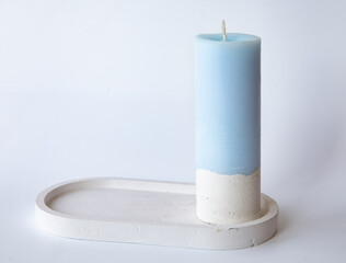 One Elegant Blue Hand made Candle on Concrete Stand on white background Home Decor Details. Flare Copy space Close-up