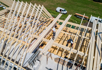 Baubranche - Handwerk, ein Dachstuhl wird auf einem Wohnhausneubau errichtet.