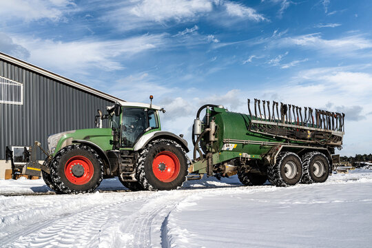 Wintereinbruch in der Landwirtschaft, Traktor mit Güllefass im Schnee.