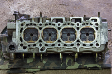 The cylinder head is 16-valve. Part of a car engine. Repair of the internal combustion engine.