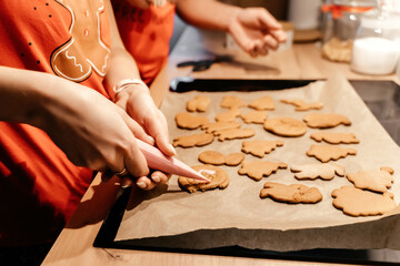 A family in Christmas pajamas cooking ginger cookies in the kitchen