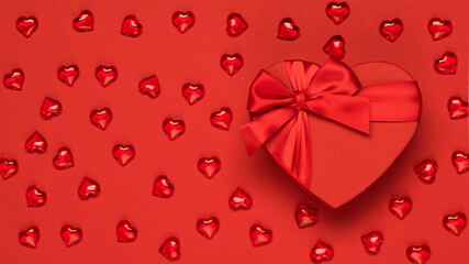 Valentine's Day background with red hearts and festive box. Flat lay, copy space