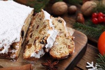 Fototapeta na wymiar Traditional Christmas Stollen with icing sugar on wooden table, closeup