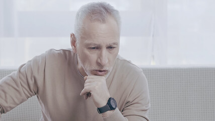 pensive mature man talking in consulting room during psychotherapy