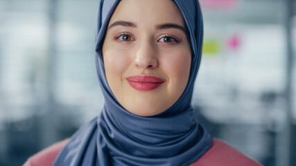 Close-up Portrait of Muslim Businesswoman Wearing Hijab Looks at Camera and Smiles. Beautiful Woman Wearing Traditional Headscarf. Successful Empowered Arab Woman.