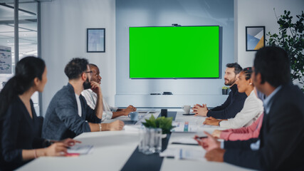 Multi-Ethnic Office Conference Room Meeting: Diverse Team of Successful Managers, Executives Talk, Use Green Screen Chroma Key TV. Businesspeople Investing in eCommerce Startup.
