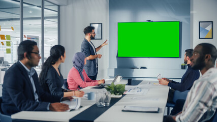 Office Conference Room Meeting Presentation: Hispanic Businessman Talks, Uses Green Screen Chroma Key Wall TV. Successfully Presenting a Product to Group of Multi-Ethnic Investors. e-Commerce Strategy