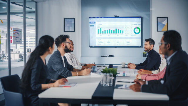 Multi-Ethnic Office Conference Room Meeting: Diverse Team of Managers, Executives Talk, Uses Wall TV with Big Data Analysis, Charts and Infographics. Businesspeople Investing in e Commerce Startup - Powered by Adobe