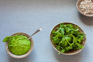 Fresh homemade arugula green pesto dip in bowl. Vegan diet.