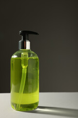 Bottle of liquid soap on grey table. Space for text