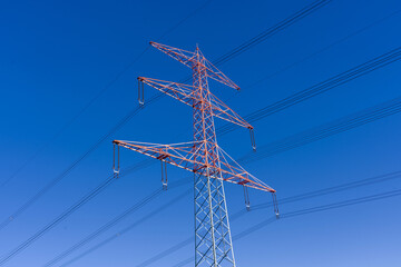 Roter Strommast vor blauem Himmel