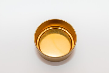 Yellow golden round empty metal box on white background.Soft focus,top view,copy space.