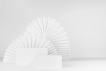 Set of two rectangle white podiums mockup with oriental paper fans as decor in modern minimal style, stage for presentation of cosmetic product or goods, advertising, design, copy space, front view.