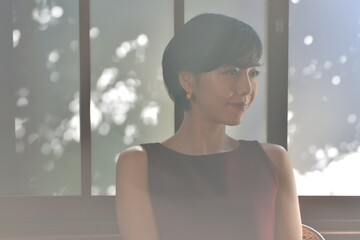 室内にてくつろぐショートヘアの清楚な微笑む女性