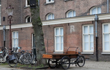 Fototapeta na wymiar Amsterdam Binnengasthuis Area Street View with Parked Bicycles and Vintage Bicycle Cart, Netherlands