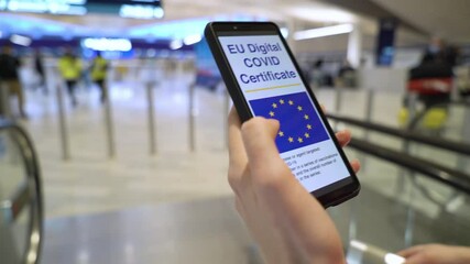 Female passenger using EU international digital health passport app in mobile phone with covid-19 vaccination certificate QR code at airport. Safe travel during coronavirus pandemic and restrictions. - Powered by Adobe