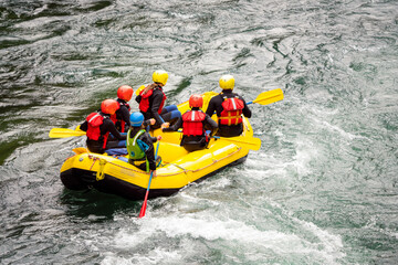 People rafting white watered river with yellow raft. Removed all logos. Water sports and adrenaline...