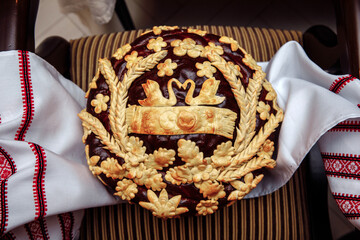 The wedding loaf is decorated with flowers. Lush round bread. Ukrainian traditions.