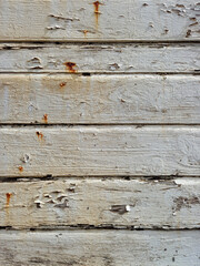 Uncorked white wood slat wall background. Texture of old wall of rusty white wooden panels. Construction and architecture detail.