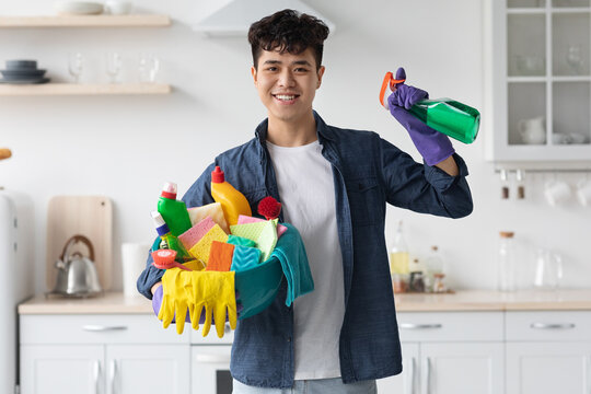 Smiling asian man house-keeper cleaning apartment, copy space