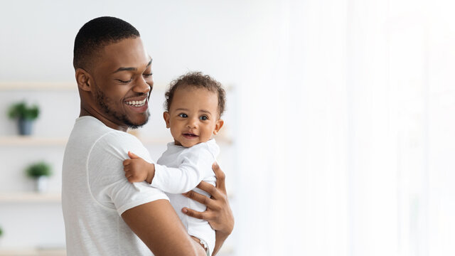 Father And Baby. Portrait Of Happy Black Millennial Dad Holding Infant Child In Arms