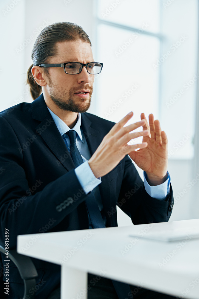 Wall mural male manager with glasses works in an office or computer