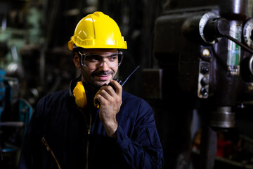 Portrait of confident engineering architect builder wearing protective hardhat working at Metal lathe industrial manufacturing factory. Engineer Operating  lathe Machinery