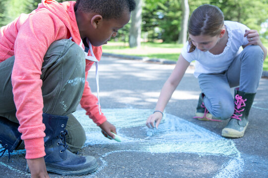 elementary students creating sidewalk art with chalk