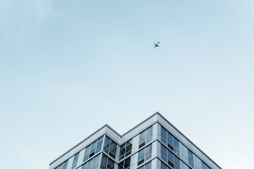 Fototapeta na wymiar modern office building with sky and airplane
