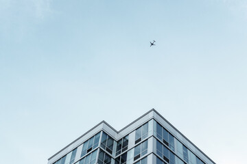 Obraz premium modern office building with sky and airplane