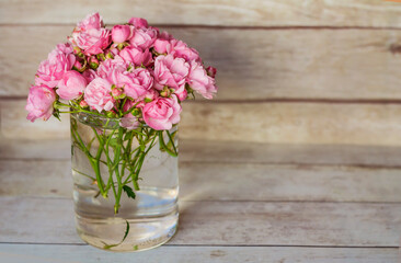 Beautiful Pink Roses Bouquet in Vase  on a Wooden Background  