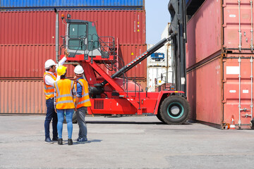 Group of professional dock worker and engineering people wearing hardhat safety helmet and vest working at container yard port of import export. Business teamwork concept