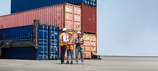 Hispanic man harbor worker talking on the walkie-talkie radio and control loading containers at container warehouse. container yard port of import and export goods - obrazy, fototapety, plakaty