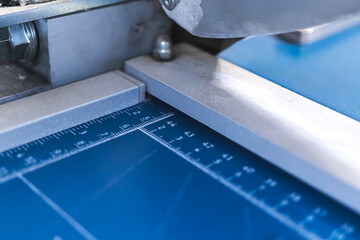 Print house industry, paper cutter machine workplace close-up view