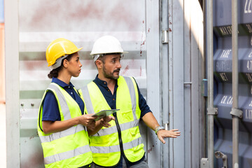 Hispanic Man worker and woman Supervisor dock cargo checking and control loading Containers box at container yard port of import and export goods. Unity and teamwork concept