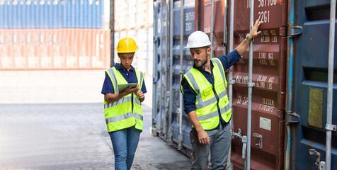 Hispanic Man worker and woman Supervisor dock cargo checking and control loading Containers box at container yard port of import and export goods. Unity and teamwork concept
