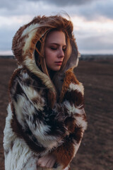 Beauty blondie young woman outdoors in fashion fur coat in sunset