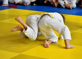 Two Girls judoka in kimono compete on the tatami 
