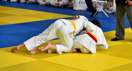 Two Girls judoka in kimono compete on the tatami 