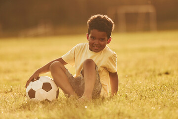 Beautiful sunshine. African american kid have fun in the field at summer daytime