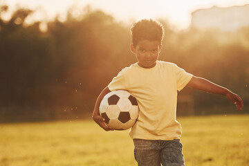 Young soccer player. African american kid have fun in the field at summer daytime