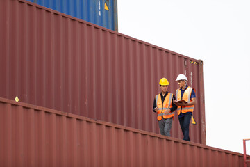 Two Asian man engineer worker wearing hardhat safety helmet and vest working in  logistic shipping...