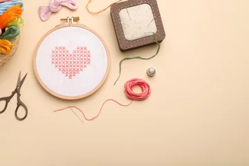 Fotobehang Flat lay composition with embroidery and different sewing accessories on beige background. Space for text © New Africa