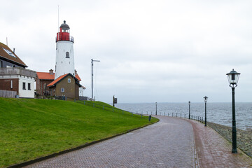White lighthouse in the Dutch fishing village Urk. - obrazy, fototapety, plakaty