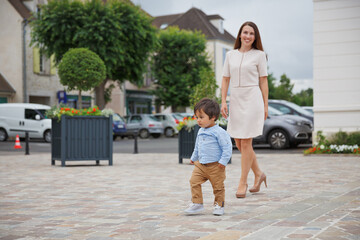 Portrait of a little eastern handsome baby boy playing with mother outdoor in the park. Arabian child fun on the street.
