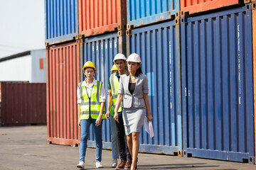 Group of professional dock worker and engineering people wearing hardhat safety helmet and vest working at container yard port of import export. Business teamwork concept