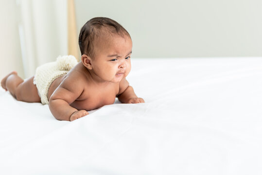 Portrait images of African baby newborn is 3 month year old, Lying on white bed in bedroom, to African newborn concept.