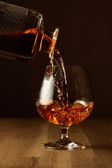 Brandy is poured into a snifter glass.